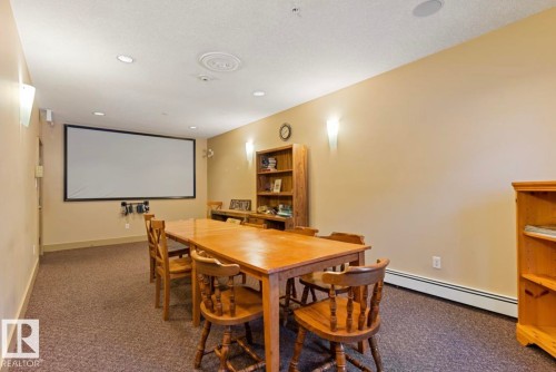 Media room featuring a large projection screen, recessed lighting, and wall sconces - #203 17407 99 Av Nw, Edmonton, AB - Indoor Photo Showing Dining Room