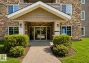 Building entrance featuring stone veneer, siding, and a covered porch - #203 17407 99 Av Nw, Edmonton, AB  - Outdoor 