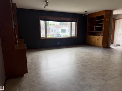 Tiled flooring, built-in shelving, wood-framed window, track lighting, and a neutral wall finish - 