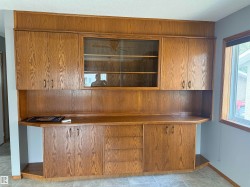 Built-in cabinetry featuring wood-finish paneling, glass-front upper cabinets, and a solid countertop - 