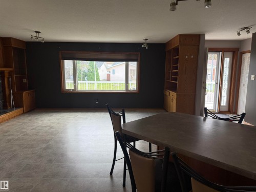 Built-in shelving units, a large window with wood trim, and a patio door with an integrated sidelight - 1412 63 Street Nw, Edmonton, AB 