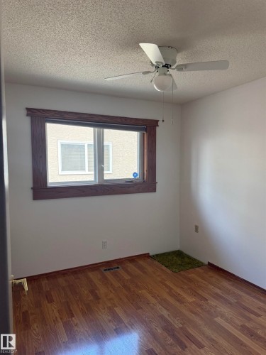 Wood-finish flooring, white walls, and a window with wood trim - 1412 63 Street Nw, Edmonton, AB 