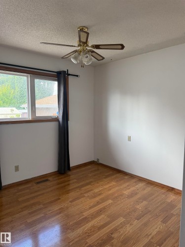 Wood-finish flooring, white walls, and a ceiling fan with integrated lighting - 1412 63 Street Nw, Edmonton, AB 