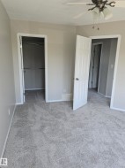 Room featuring light gray walls, white trim, and gray carpeting - 