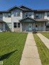 Townhome exterior featuring light gray siding, dark gray trim, and stone veneer accents - 4120 47 Street, Drayton Valley, AB  - Outdoor With Facade 