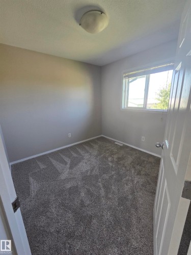 Gray-toned wall paint and textured gray carpet with white baseboards - 4120 47 Street, Drayton Valley, AB - Indoor Photo Showing Other Room
