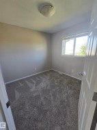 Gray-toned wall paint and textured gray carpet with white baseboards - 