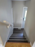 Stairwell featuring light gray walls and wood-finish flooring - 