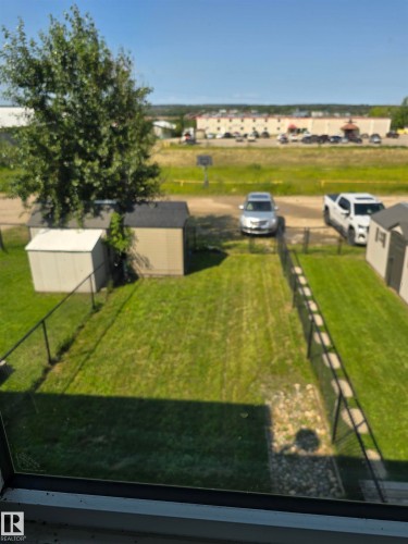Enclosed rear yard featuring a manicured lawn and black metal fencing - 4120 47 Street, Drayton Valley, AB - Outdoor With View