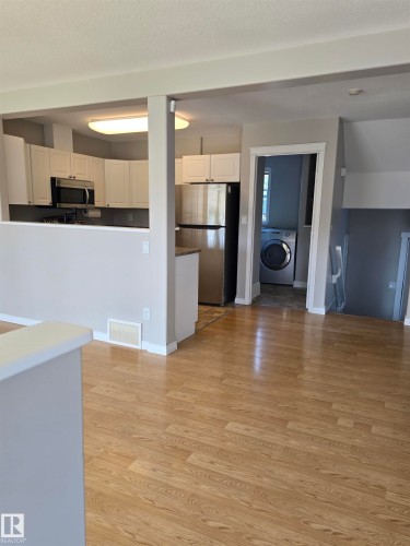 Open-concept living area featuring wood-finish flooring, white baseboards, and neutral wall tones - 4120 47 Street, Drayton Valley, AB - Indoor Photo Showing Kitchen