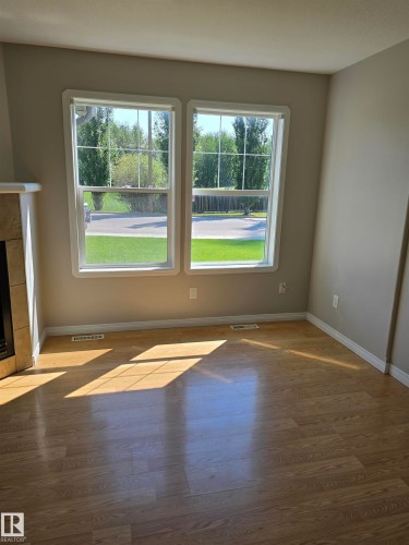 Two double-hung windows with white trim, wood-finish flooring, and light-colored wall paint - 4120 47 Street, Drayton Valley, AB - Indoor With Fireplace