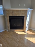 Corner fireplace with a tile surround and a light-colored mantel - 