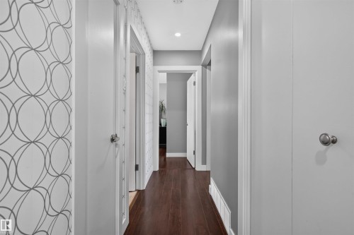 Hallway featuring wood-finish flooring, recessed lighting, and modern wallpaper accents - 12136 135A Avenue Nw, Edmonton, AB - Indoor Photo Showing Other Room