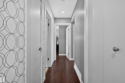 Hallway featuring wood-finish flooring, recessed lighting, and modern wallpaper accents - 