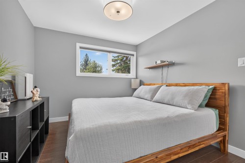 Well-lit interior space featuring neutral gray walls and dark wood-finish flooring - 12136 135A Avenue Nw, Edmonton, AB - Indoor Photo Showing Bedroom