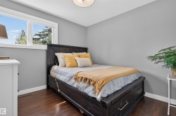 Bright room featuring a large window, dark wood-finish flooring, and light gray walls - 