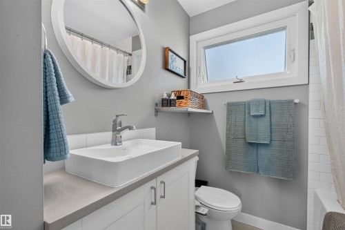 Bathroom vanity with a rectangular vessel sink, chrome faucet, and concrete-finish countertop - 12136 135A Avenue Nw, Edmonton, AB - Indoor Photo Showing Bathroom