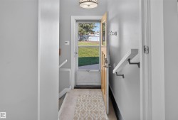 Entryway featuring a natural wood-finish door with glass paneling, overhead drum light fixture, and a patterned floor mat - 