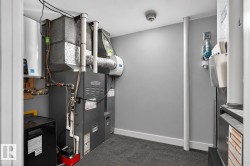 Dedicated utility room featuring a tankless water heater, furnace system, and ductwork - 