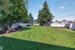 Expansive lawn area enclosed by a white privacy fence - 