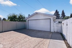 Detached garage featuring a white overhead door and siding - 