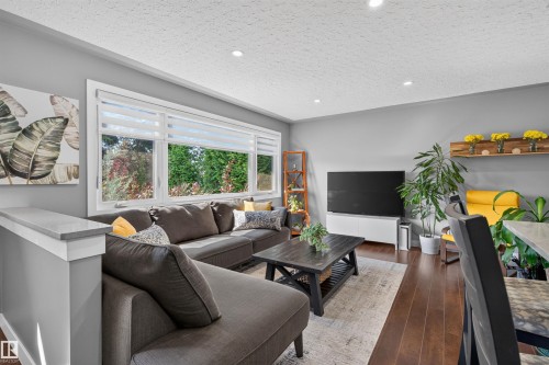 Spacious living area featuring large windows, recessed lighting, and wood-finish flooring - 12136 135A Avenue Nw, Edmonton, AB - Indoor Photo Showing Living Room With Fireplace