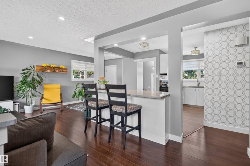 Open-concept living space featuring wood-finish flooring, recessed lighting, and a neutral color palette - 12136 135A Avenue Nw, Edmonton, AB - Indoor
