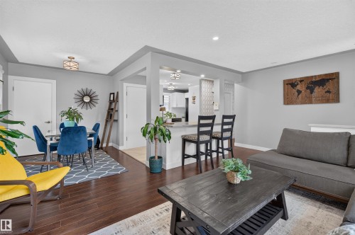 Open-concept living space featuring wood-finish flooring, recessed lighting, and a neutral color palette - 12136 135A Avenue Nw, Edmonton, AB - Indoor Photo Showing Living Room