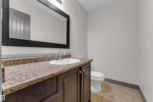 Vanity featuring a patterned countertop with an integrated sink and chrome faucet - 11817 37 Street Nw, Edmonton, AB - Indoor Photo Showing Bathroom