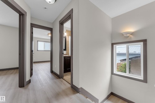 Hallway with wood-finish flooring, white walls, and dark trim - 11817 37 Street Nw, Edmonton, AB - Indoor Photo Showing Other Room