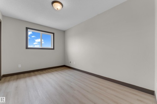 Room featuring light wood-finish flooring, a neutral wall color, and dark trim - 11817 37 Street Nw, Edmonton, AB - Indoor Photo Showing Other Room