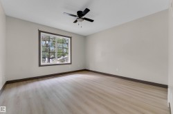 Spacious interior room featuring light wood-finish flooring, neutral wall paint, and dark trim details - 