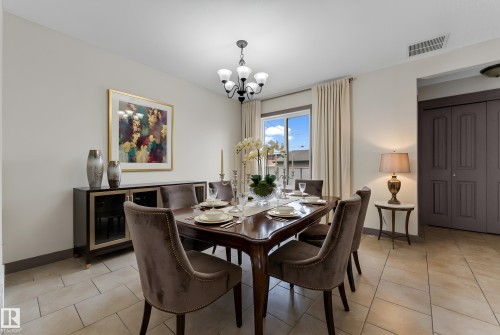 Dining area featuring ceramic tile flooring, a multi-pane window with drapes, and a black chandelier - 11817 37 Street Nw, Edmonton, AB - Indoor Photo Showing Dining Room