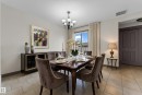 Dining area featuring ceramic tile flooring, a multi-pane window with drapes, and a black chandelier - 11817 37 Street Nw, Edmonton, AB  - Indoor Photo Showing Dining Room 