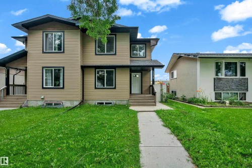 Two-story residence featuring light brown horizontal siding with contrasting black trim windows and dark roofline - 11817 37 Street Nw, Edmonton, AB - Outdoor With Facade