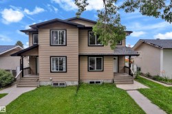 Two-story duplex featuring tan siding and black trim around windows - 