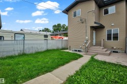 Rear exterior featuring neutral-toned horizontal siding, a multi-tiered deck with stairs, and a concrete patio - 