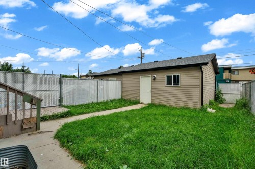 Detached structure featuring light beige siding, an asphalt shingle roof, and a white entry door - 11817 37 Street Nw, Edmonton, AB - Outdoor