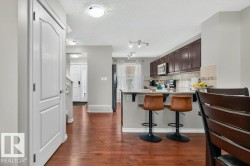 Kitchen featuring dark wood cabinetry, stainless steel appliances, and a light-toned countertop with an integrated sink - 