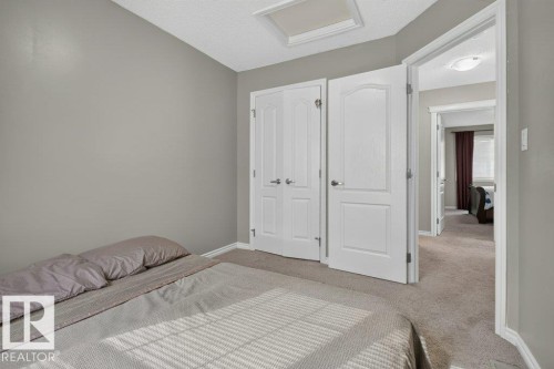 Neutral-toned bedroom with textured carpet flooring - 692 Secord Boulevard Nw, Edmonton, AB - Indoor Photo Showing Bedroom