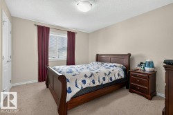 Carpeted room featuring a double-pane window with blinds and red drapery, light-toned walls, and a white ceiling light fixture - 