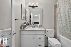 Bathroom featuring a white vanity with built-in storage, a basin sink with a chrome faucet, and a wall-mounted medicine cabinet with integrated lighting - 