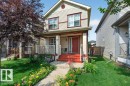 Two-story residence featuring light-colored horizontal siding and a prominent red front door - 692 Secord Boulevard Nw, Edmonton, AB  - Outdoor With Deck Patio Veranda 