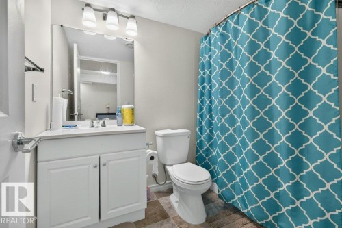 Bathroom featuring a white vanity with integrated sink, chrome faucet, and white cabinetry - 692 Secord Boulevard Nw, Edmonton, AB - Indoor Photo Showing Bathroom