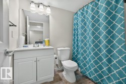 Bathroom featuring a white vanity with integrated sink, chrome faucet, and white cabinetry - 