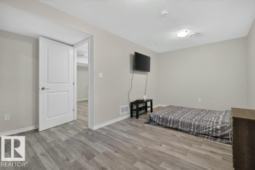 Room featuring light gray walls and wood-finish flooring - 692 Secord Boulevard Nw, Edmonton, AB - Indoor Photo Showing Bedroom