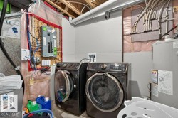 Utility area featuring exposed ceiling joists, partially finished walls, and a water heater - 
