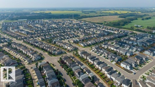 Aerial perspective showcasing a residential community with numerous single-family homes, organized street grids, and consistent architectural styles - 692 Secord Boulevard Nw, Edmonton, AB -  With View
