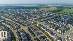 Aerial perspective showcasing a residential community with numerous single-family homes, organized street grids, and consistent architectural styles - 