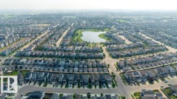 Aerial perspective showcasing a residential community with a central lake feature - 
